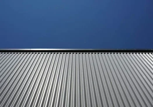 Corrugated metal roofing panels beneath a clear blue sky